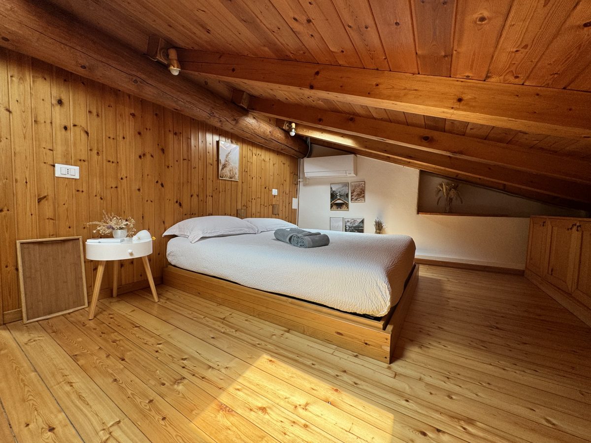 Bedroom under the sloping mansard ceiling with air conditioning