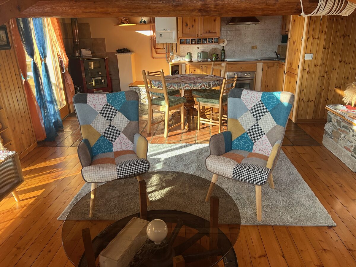 Living room with wooden beams, armchairs and lake view windows
