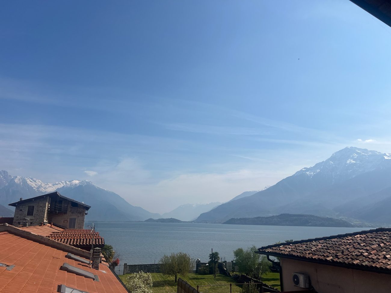The view from Casa Elenina: terracotta rooftops, Lake Como and snow-capped mountains
